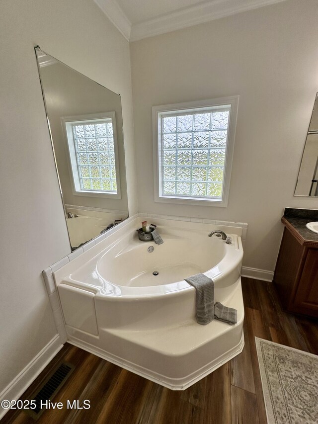 146 N Ravenwood Ln, Belhaven, NC 27810 - full bath featuring wood finished floors, crown molding, a garden tub, vanity, and baseboards