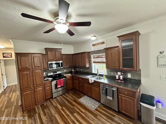 146 N Ravenwood Ln, Belhaven, NC 27810 - kitchen featuring appliances with stainless steel finishes, a sink, dark countertops, decorative backsplash, and crown molding