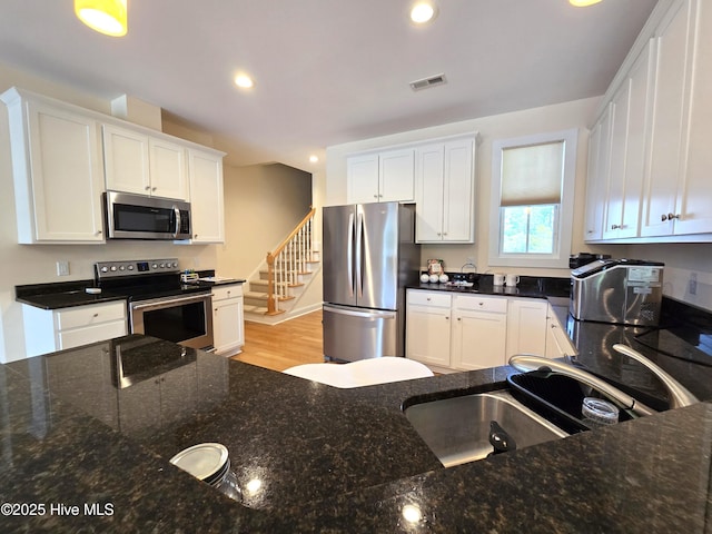 105 Argosy Dr, New Bern, NC 28560 - kitchen featuring appliances with stainless steel finishes, white cabinetry, dark stone counters, and recessed lighting