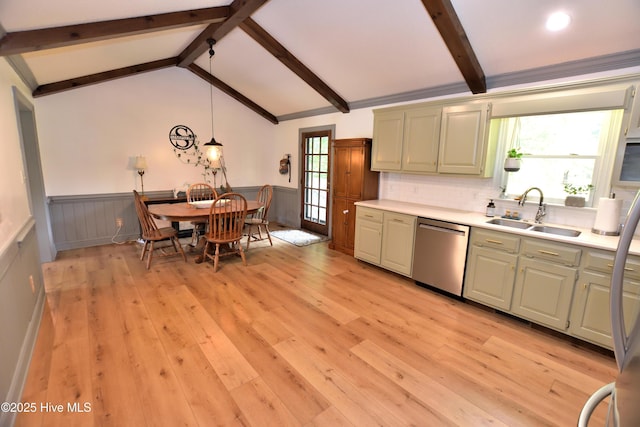 kitchen featuring dishwasher, a sink, wainscoting, light countertops, and light wood finished floors