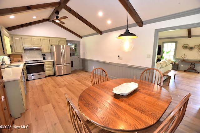 dining area with a wainscoted wall, ceiling fan, and light wood-style flooring