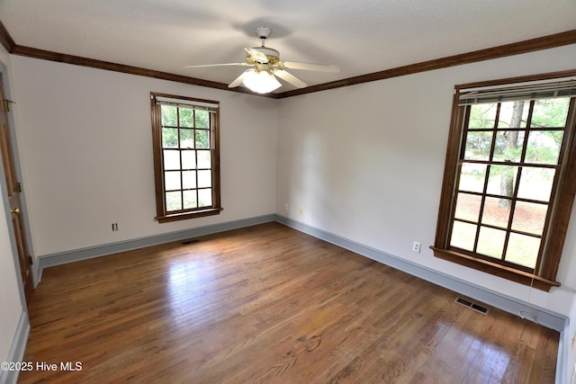 unfurnished room featuring wood finished floors, ornamental molding, a ceiling fan, and baseboards