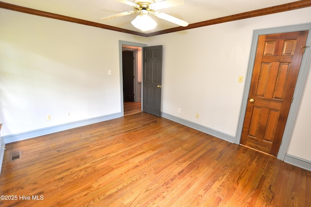 empty room with light wood-style floors, crown molding, baseboards, and ceiling fan