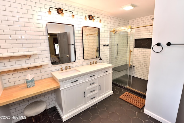 full bathroom with walk in shower, double vanity, tasteful backsplash, tile patterned flooring, and baseboards