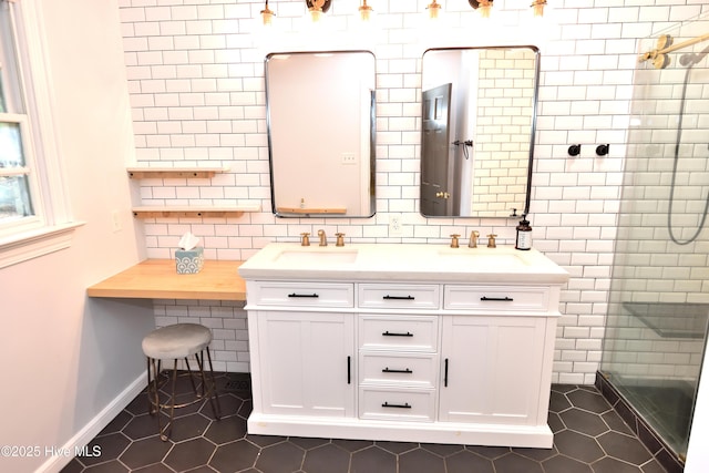 bathroom featuring tile patterned flooring, double vanity, a tile shower, and backsplash