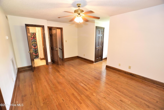 spare room featuring a ceiling fan, light wood-style floors, and baseboards