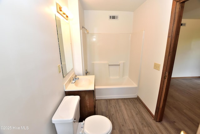 full bathroom with wood finished floors, toilet, tub / shower combination, vanity, and baseboards