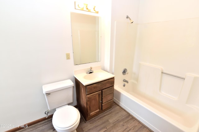 full bath featuring wood finished floors, toilet, washtub / shower combination, and vanity