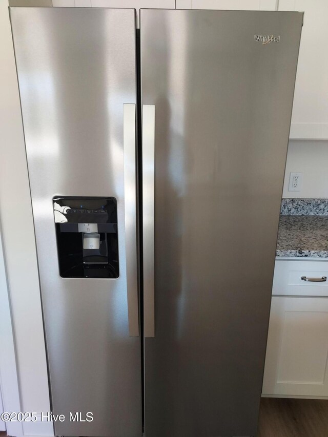 97 Hadnot Dr Unit B, Swansboro, NC 28584 - kitchen view of stainless steel fridge, light stone counters, white cabinetry, and dark wood finished floors