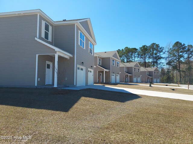 97 Hadnot Dr Unit B, Swansboro, NC 28584 - view of home's exterior featuring an attached garage, concrete driveway, a residential view, and a yard