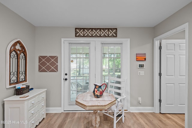 dining space with light wood-style flooring and baseboards