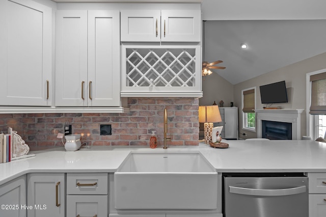 kitchen with dishwasher, a sink, open floor plan, decorative backsplash, and vaulted ceiling