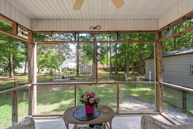 unfurnished sunroom with ceiling fan