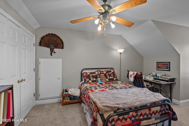 carpeted bedroom featuring lofted ceiling, baseboards, ceiling fan, and a closet