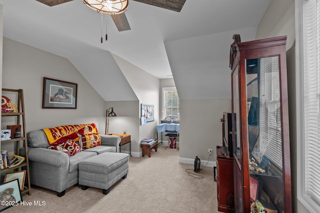 living area with a ceiling fan, light colored carpet, baseboards, and vaulted ceiling