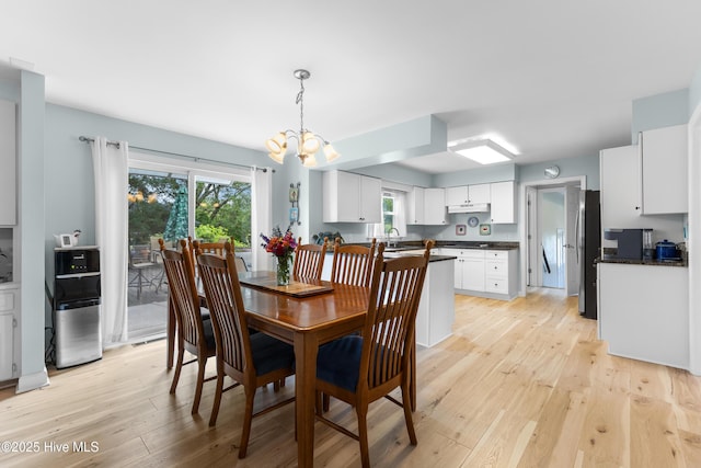 209 Inlet Dr, Wilmington, NC 28411 - dining space featuring a chandelier, light wood-style flooring, and healthy amount of natural light