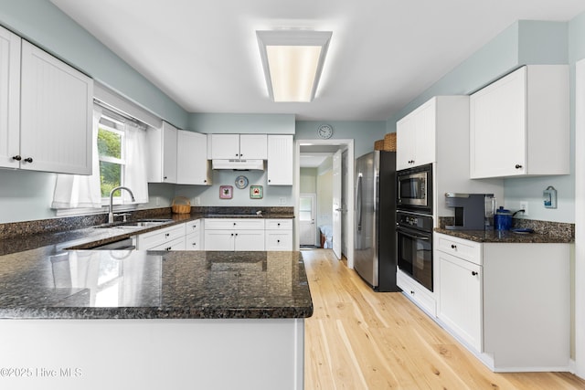 209 Inlet Dr, Wilmington, NC 28411 - kitchen featuring black appliances, a sink, a peninsula, and white cabinetry