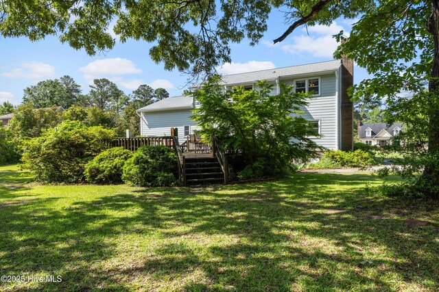 209 Inlet Dr, Wilmington, NC 28411 - rear view of house with a deck, a chimney, and a yard