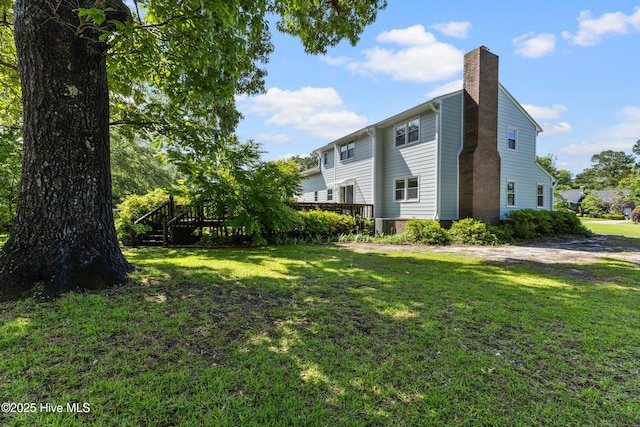 209 Inlet Dr, Wilmington, NC 28411 - view of property exterior featuring a chimney, a yard, and a wooden deck