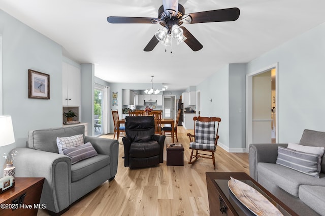 209 Inlet Dr, Wilmington, NC 28411 - living room featuring a ceiling fan, light wood finished floors, and a chandelier