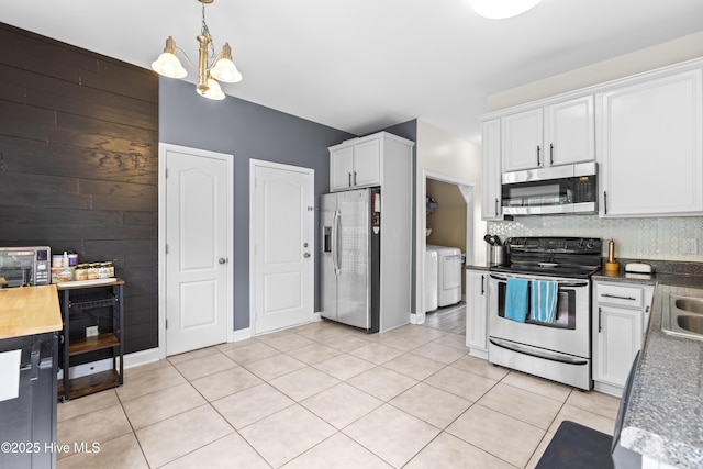 112 Norine Dr, Holly Ridge, NC 28445 - kitchen with stainless steel appliances, independent washer and dryer, white cabinets, light tile patterned floors, and pendant lighting