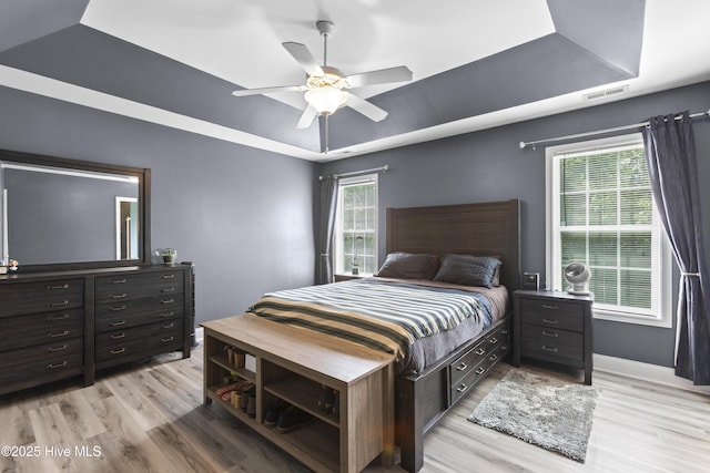 112 Norine Dr, Holly Ridge, NC 28445 - bedroom with a tray ceiling, light wood finished floors, ceiling fan, and baseboards