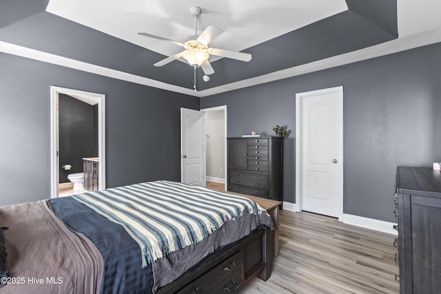 112 Norine Dr, Holly Ridge, NC 28445 - bedroom with a raised ceiling, light wood-type flooring, baseboards, connected bathroom, and ceiling fan
