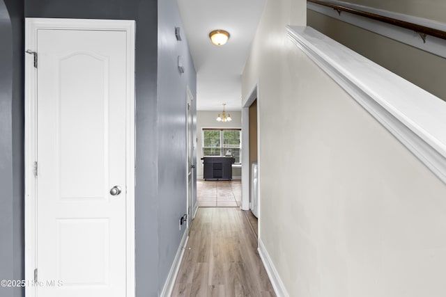 112 Norine Dr, Holly Ridge, NC 28445 - hallway with light wood-style flooring, baseboards, and a chandelier