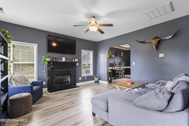 112 Norine Dr, Holly Ridge, NC 28445 - living area featuring arched walkways, wood finished floors, a ceiling fan, a fireplace, and baseboards
