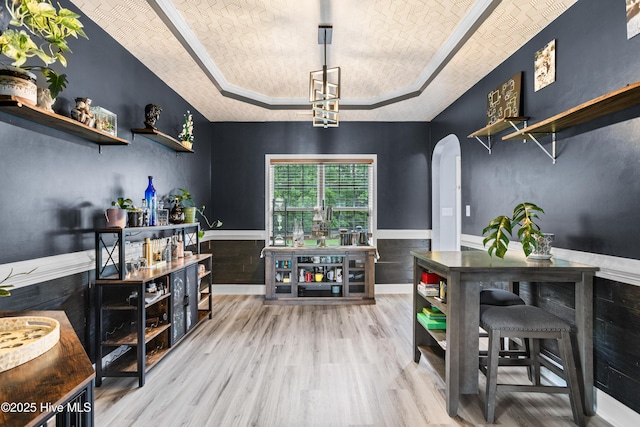 112 Norine Dr, Holly Ridge, NC 28445 - bar featuring a raised ceiling, arched walkways, wood finished floors, and a wainscoted wall