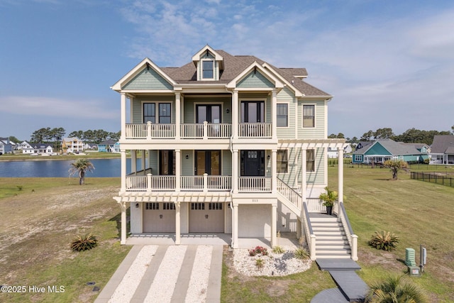 353 Spicer Lake Dr, Holly Ridge, NC 28445 - coastal home with a balcony, a water view, an attached garage, driveway, and a front yard
