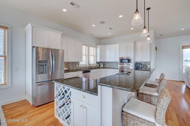 353 Spicer Lake Dr, Holly Ridge, NC 28445 - kitchen featuring appliances with stainless steel finishes, tasteful backsplash, white cabinets, light wood-style flooring, and recessed lighting
