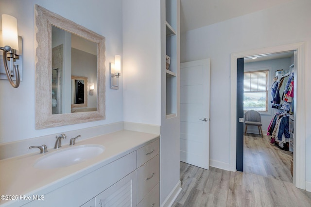353 Spicer Lake Dr, Holly Ridge, NC 28445 - bathroom with wood finished floors, a walk in closet, vanity, baseboards, and a shower