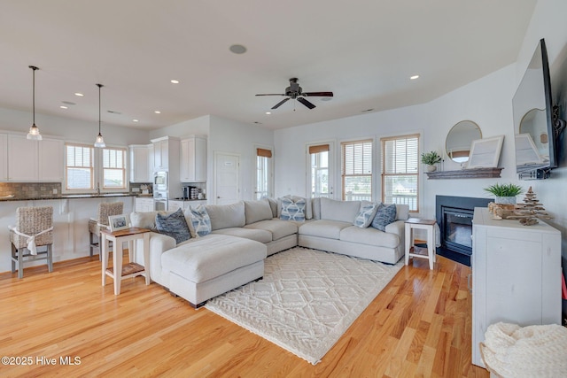 353 Spicer Lake Dr, Holly Ridge, NC 28445 - living area with light wood-style flooring, ceiling fan, a glass covered fireplace, and recessed lighting