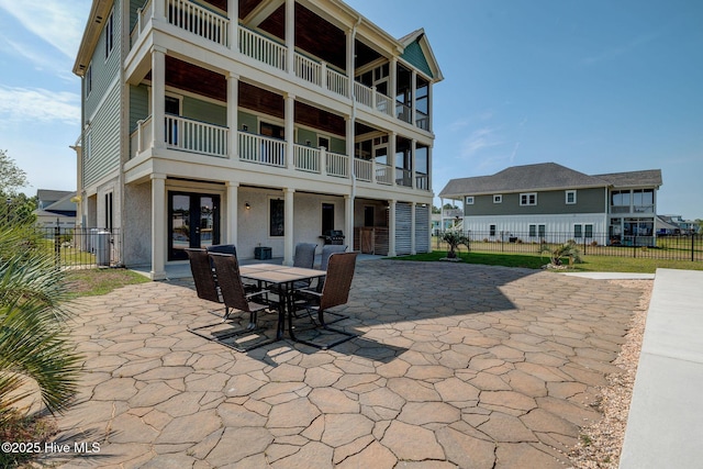 353 Spicer Lake Dr, Holly Ridge, NC 28445 - rear view of house featuring fence, a patio, french doors, and outdoor dining area