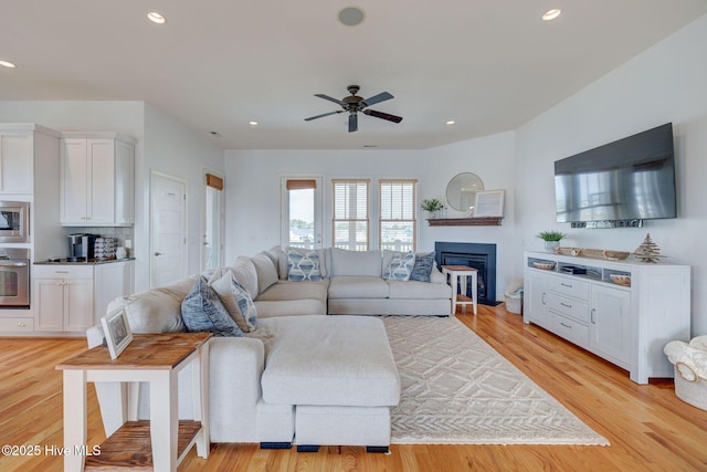 353 Spicer Lake Dr, Holly Ridge, NC 28445 - living room featuring a ceiling fan, light wood-type flooring, recessed lighting, and a glass covered fireplace
