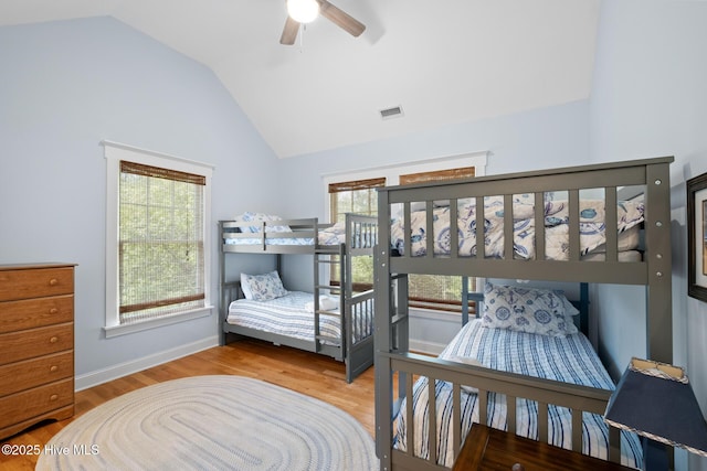 bedroom featuring lofted ceiling, multiple windows, wood finished floors, and a ceiling fan