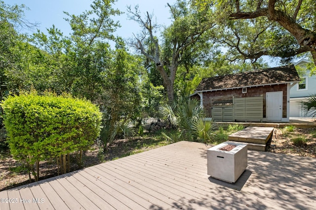deck with a fire pit and an outdoor structure