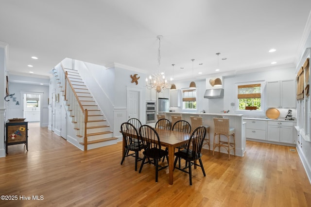 dining area featuring stairway, a chandelier, light wood-type flooring, crown molding, and recessed lighting