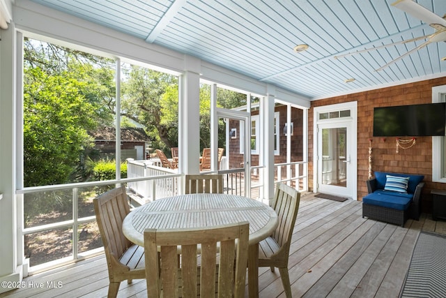 sunroom featuring outdoor dining area