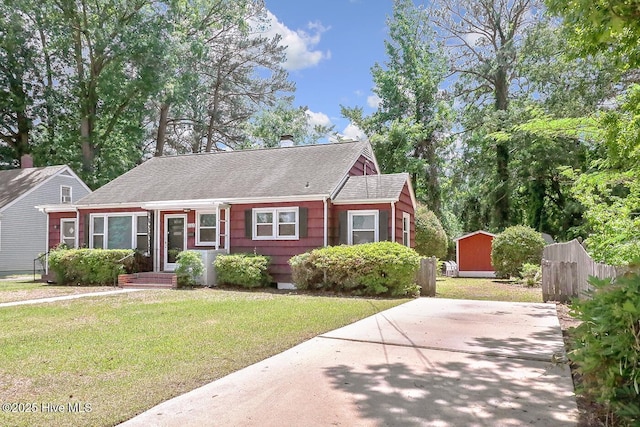 1111 Baxter St, Elizabeth City, NC 27909 - view of front of property with a shed, an outdoor structure, a shingled roof, and a chimney