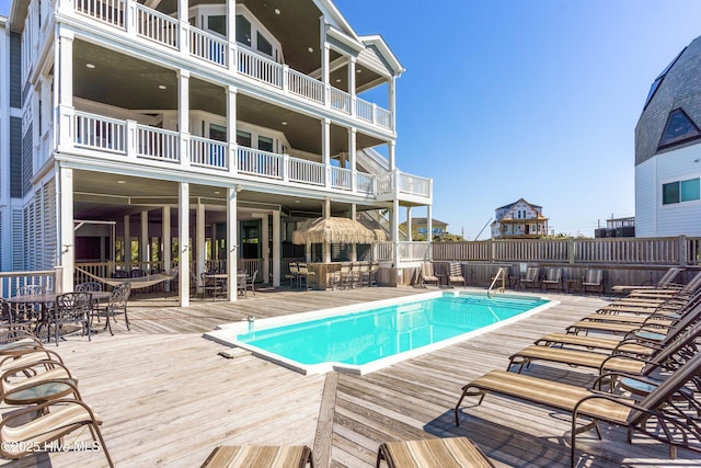community pool featuring a wooden deck and outdoor dining area