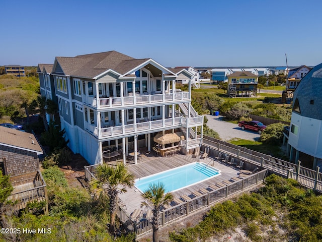 rear view of property with a wooden deck and a balcony