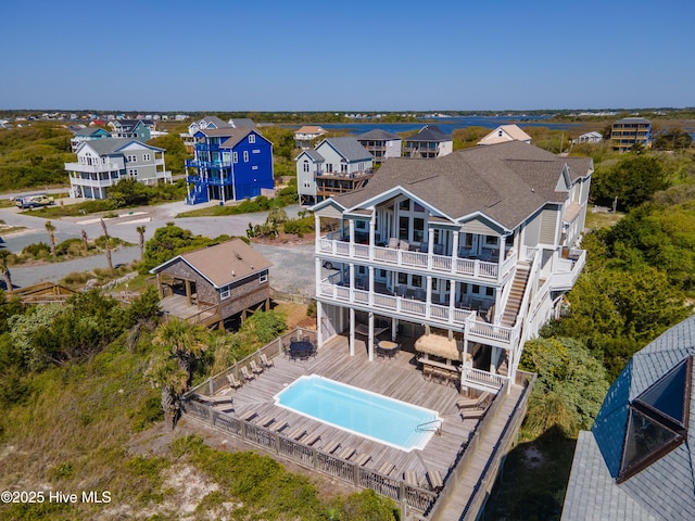 rear view of house featuring a deck, a balcony, and a residential view