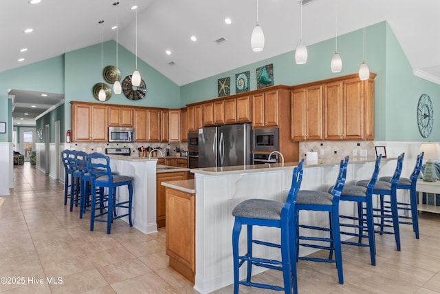 kitchen with stainless steel appliances, a peninsula, high vaulted ceiling, a breakfast bar, and decorative backsplash