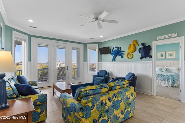 living area with light tile patterned flooring, ornamental molding, a ceiling fan, wainscoting, and recessed lighting