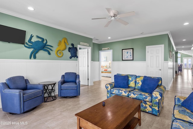 living room with a wainscoted wall, tile patterned flooring, recessed lighting, ornamental molding, and ceiling fan