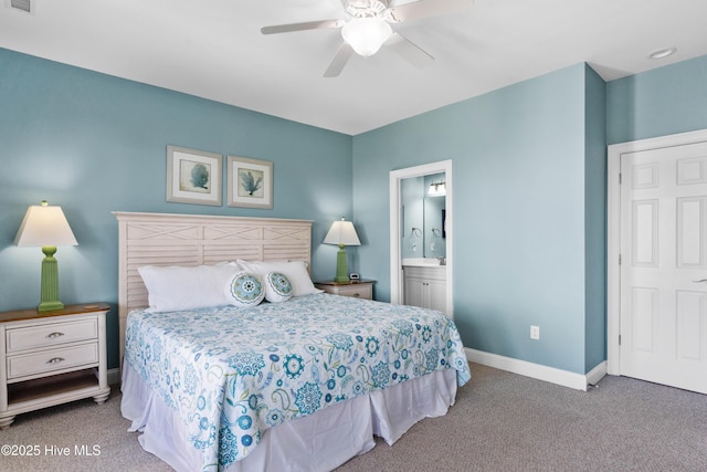 carpeted bedroom featuring baseboards, ensuite bath, and a ceiling fan