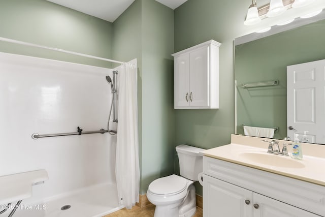full bath with a stall shower, toilet, vanity, baseboards, and tile patterned flooring