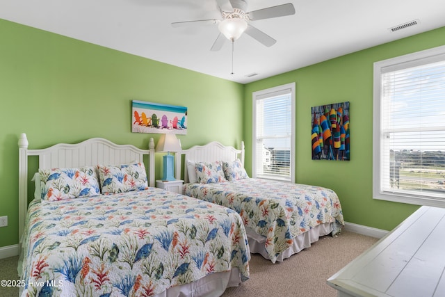 carpeted bedroom with multiple windows, baseboards, and a ceiling fan